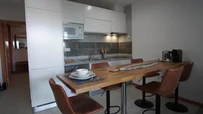 a kitchen with a wooden table and some chairs at Geams Sal Suite in Santa Maria