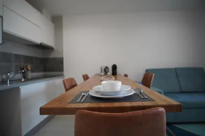 a wooden table with a cup of coffee on it at Geams Sal Suite in Santa Maria