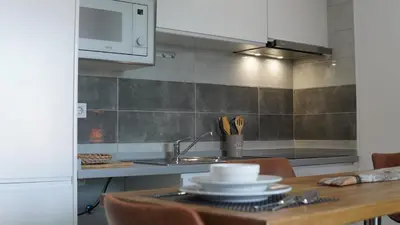 a kitchen with a table with a sink and a microwave at Geams Sal Suite in Santa Maria