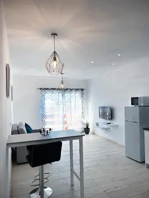 a living room with a table and a kitchen at P&SApartments in Santa Maria