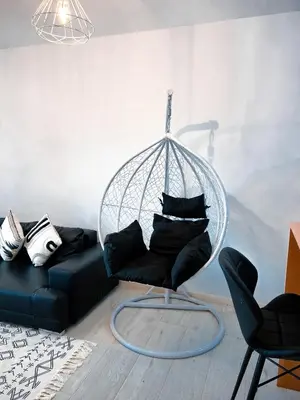 a living room with a black couch and a swing at P&SApartments in Santa Maria