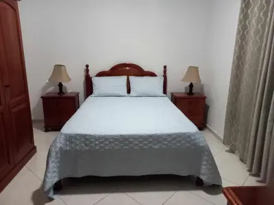 a bedroom with a bed with two nightstands and two lamps at Black Diamond - CASA Tia Bia in Ribeira Grande