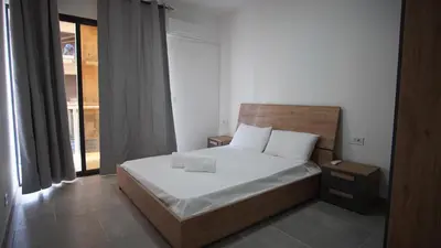 a bedroom with a bed with white sheets and a window at Atlantico Sal Apt in Santa Maria