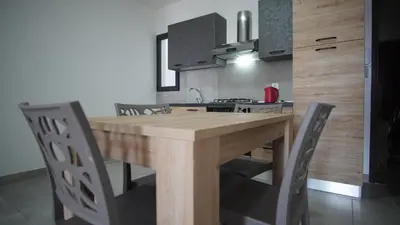 a kitchen with a wooden table and some chairs at Atlantico Sal Apt in Santa Maria