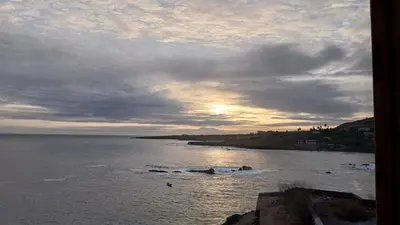 a view of the ocean with the sun setting at Get house kira in Cidade Velha
