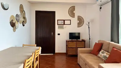 a living room with a couch and a television at T1 Vista Mar - Porto Antigo 3 in Santa Maria