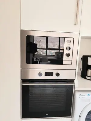 a microwave above a oven in a kitchen at Morabeza Deluxe view on the sea in Mindelo