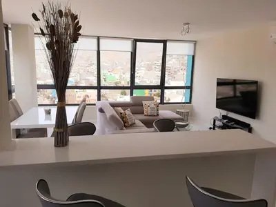 a living room with a couch and a table with chairs at Morabeza Deluxe view on the sea in Mindelo