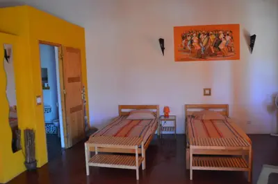 a room with two beds and a painting on the wall at Casa De France in Porto Novo