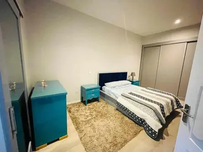 a bedroom with a bed and two blue tables at Aparthotel Pilon T3 in Praia