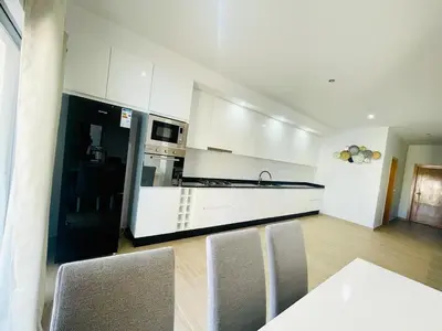 a kitchen with white cabinets and a black refrigerator at Aparthotel DI LIA T3 in Praia
