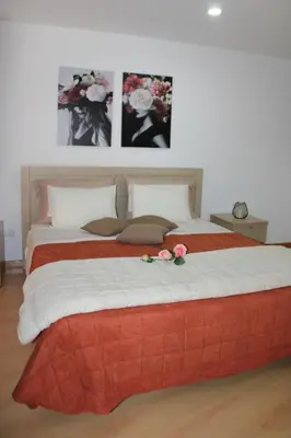 a bedroom with a large bed with two flowers on it at mezzanino Ribeira Brava in Vila da Ribeira Brava