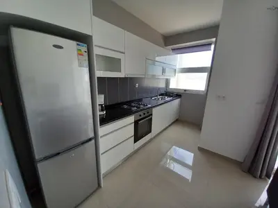 a kitchen with white cabinets and a refrigerator at SILVAs Apartment in Mindelo