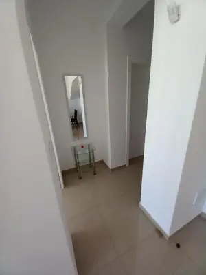 an empty white room with a mirror and a table at SILVAs Apartment in Mindelo