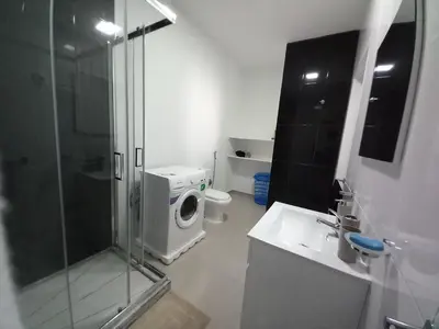 a bathroom with a shower and a washing machine at SILVAs Apartment in Mindelo