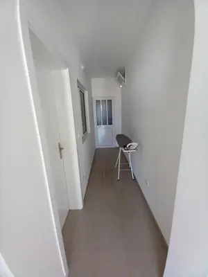 a hallway with a chair in a white room at SILVAs Apartment in Mindelo