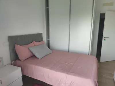 a bed with pink and grey pillows in a room at Isa Charme Home in Praia