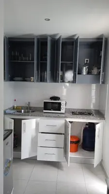 a kitchen with white cabinets and a counter top at CasaMrichica1 in Ribeira Grande