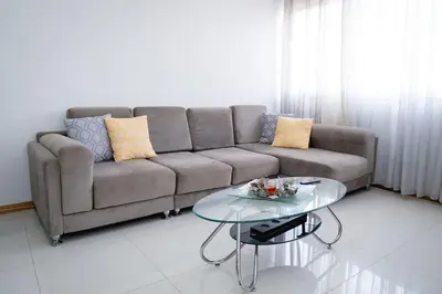 a living room with a couch and a glass table at Apartamento das Flores 2 in Praia