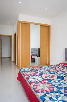 a bedroom with a bed and a living room at Apartamento das Flores 2 in Praia