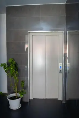 a bathroom with a potted plant next to a elevator at Apartamento das Flores 2 in Praia