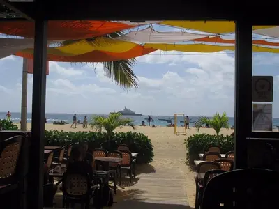 a view of a beach from a restaurant with tables and chairs at Vila Verde - Chez Val in Santa Maria