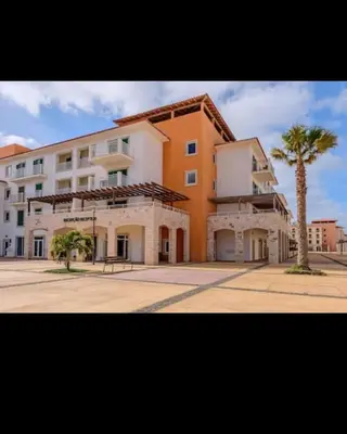 a large building with a palm tree in front of it at Vila Verde - Chez Val in Santa Maria