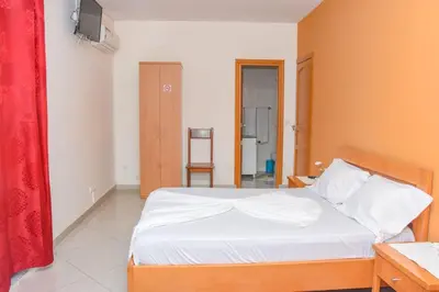 a bedroom with a white bed and a red curtain at Hot belvedere in Praia