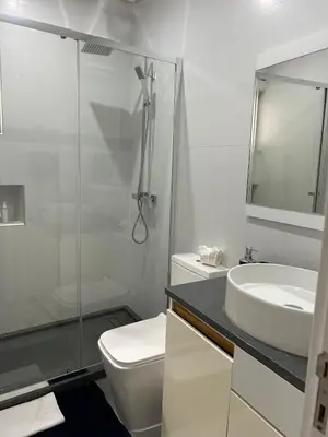 a bathroom with a toilet and a sink and a shower at Ely's Place by the Sea in Praia Baixo