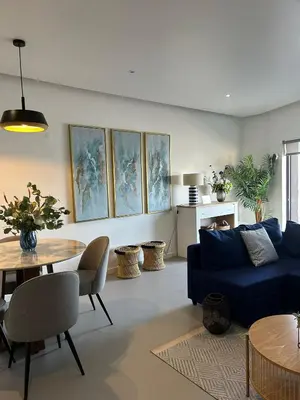 a living room with a blue couch and a table at Ely's Place by the Sea in Praia Baixo