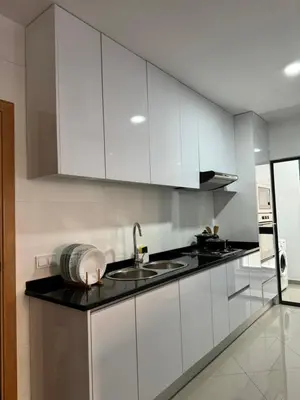 a kitchen with white cabinets and a sink at Holiday Apartments TF in Praia