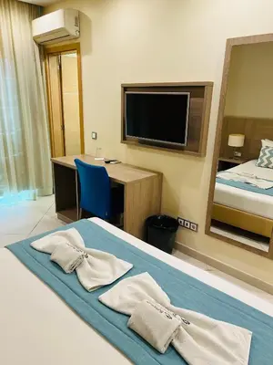 a hotel room with a bed and a desk and a tv at Beramar Hotel in Praia