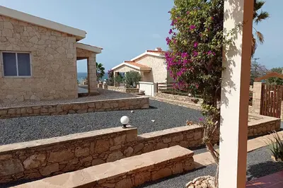 a house with a retaining wall and some flowers at Appartamento Serra. Stella Maris Exclusive in Calheta Do Maio