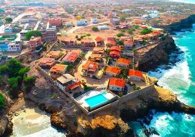 a group of houses on a cliff near the ocean at Appartamento Percebes. Stella Maris Exclusive in Calheta Do Maio