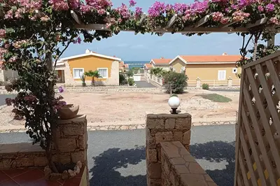an arch with pink flowers on a house at Appartamento Percebes. Stella Maris Exclusive in Calheta Do Maio
