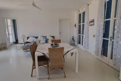 a dining room with a table and chairs and a couch at Casa Vida Boa in Sal Rei
