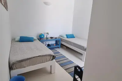 two beds in a room with blue pillows at Casa Vida Boa in Sal Rei