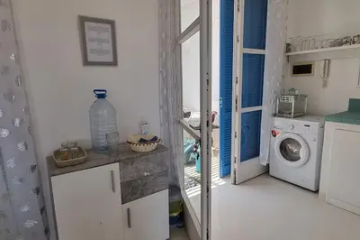 a small kitchen with a washing machine and a window at Casa Vida Boa in Sal Rei