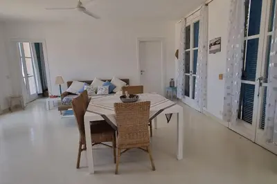 a dining room with a table and chairs and a couch at Casa Vida Boa in Sal Rei