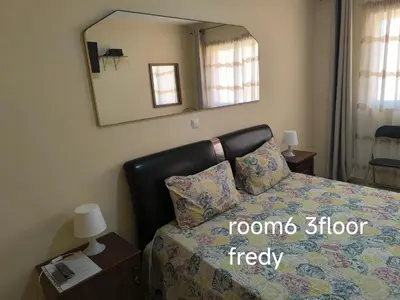 a bedroom with a bed with a mirror on the wall at guesthouse emaly in Mindelo
