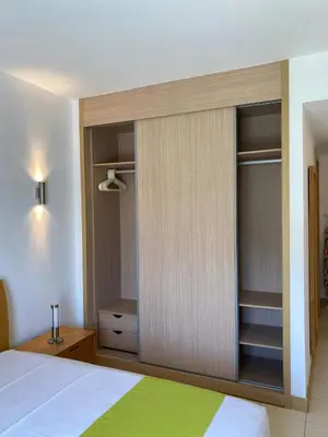 a bedroom with a large wooden closet with a bed at Mi Casa és Su Casa in Prainha