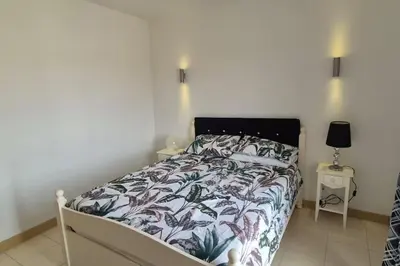 a bedroom with a bed with a floral bedspread at SUNNY Apartment - SAL VILA VERDE - Cabo Verde in Santa Maria