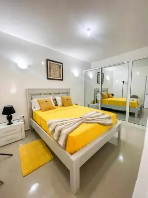 a bedroom with a large yellow bed and a mirror at Zeyden Place Apt 2 in Praia