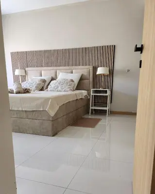 a bedroom with a large bed and a chair at Boa Mindelo Beach in Mindelo