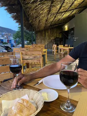 two people sitting at a table with two glasses of wine at Boa Mindelo Beach in Mindelo