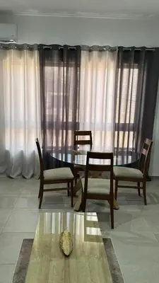 a dining room with a table and chairs and curtains at Apartamento moderno I - T1 - Cidade do Porto Novo - Ilha Santo Antão in Porto Novo