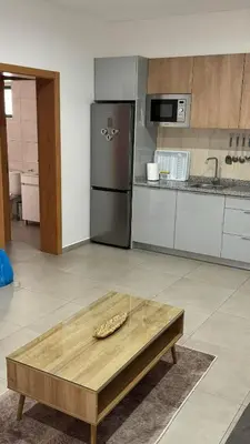 a kitchen with a coffee table and a refrigerator at Apartamento moderno I - T1 - Cidade do Porto Novo - Ilha Santo Antão in Porto Novo