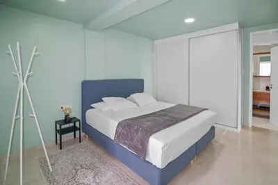 a bedroom with a large bed with a blue headboard at Sea-view Central Joy! in Mindelo