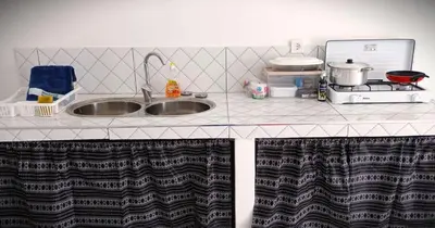 a kitchen counter with a sink and a microwave at Kaza Papaya - Papaya House in Tarrafal