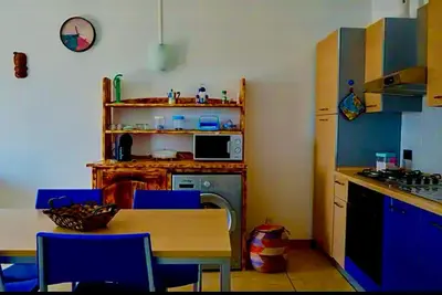 a kitchen with blue chairs and a table and a stove at Andreia in Santa Maria